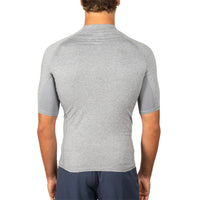 A man viewed from the back wearing a light gray short-sleeve athletic shirt with darker gray side panels, paired with navy shorts, against a plain white background.