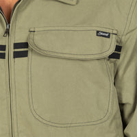 Close-up of an olive green work jacket with a large chest pocket, black stripe accents on the sleeves, and a small black embroidered 'Stewart' brand patch.