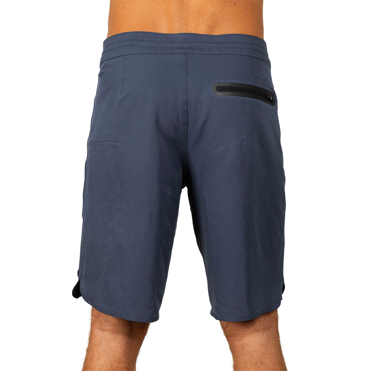 Rear view of a person wearing navy blue athletic shorts with a black zippered pocket on the upper left side, shown against a plain white background.