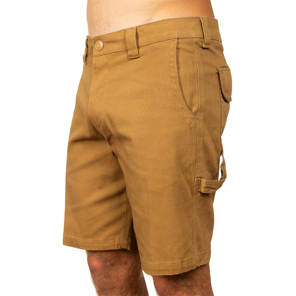 A close-up side view of a person wearing tan cargo shorts against a plain white background.