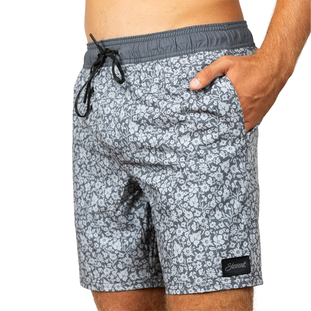 Gray and white patterned swim trunks with a dark gray elastic waistband and black drawstring, shown on a model against a white background.