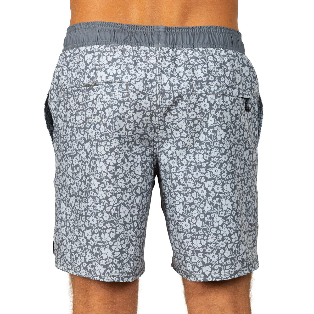Rear view of a person wearing patterned gray and white swim shorts with an elastic waistband, shown against a plain white background.
