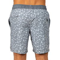 Rear view of a person wearing patterned gray and white swim shorts with an elastic waistband, shown against a plain white background.