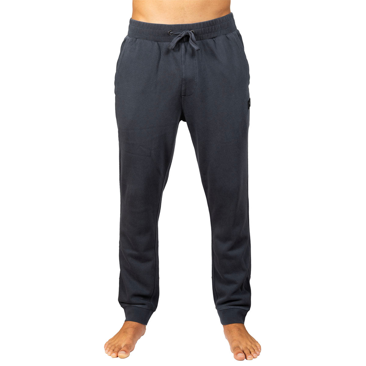 Dark gray jogger pants with an elastic waistband and drawstring, shown on a model from the waist down against a white background.