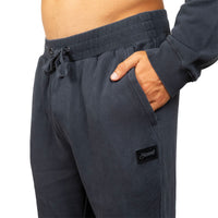 Close-up of a person wearing dark charcoal gray sweatpants with a drawstring waist and side pocket, shown against a plain white background.