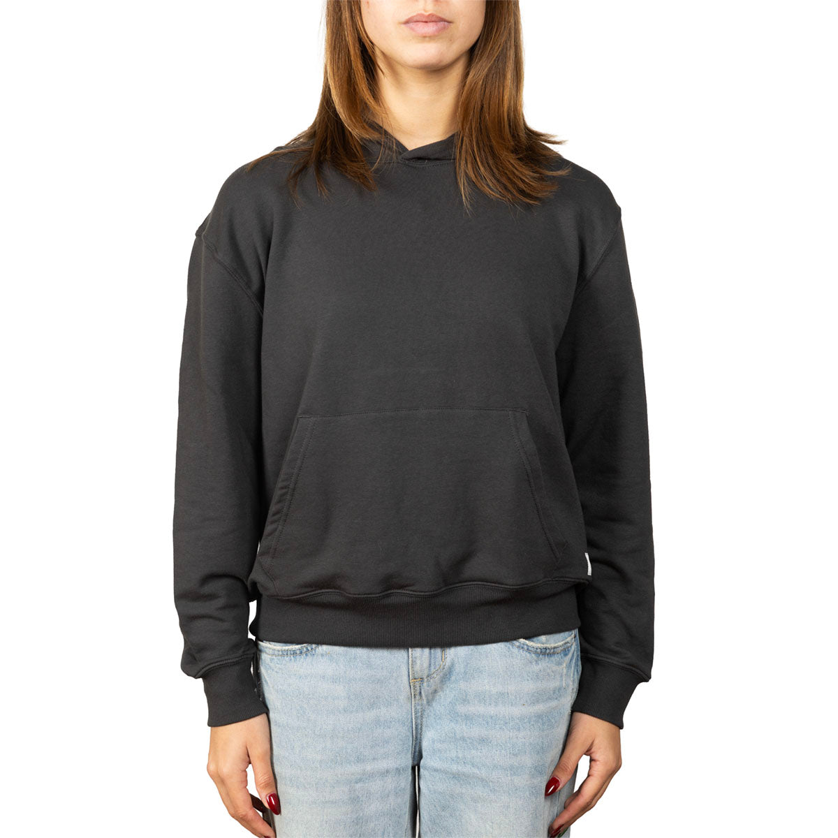 A woman wearing a black pullover hoodie with a front kangaroo pocket, paired with light-wash blue jeans, shown against a plain white background.