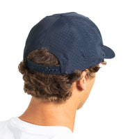 A man shown from the back wearing a navy blue perforated baseball cap with an adjustable strap, on a solid white background.