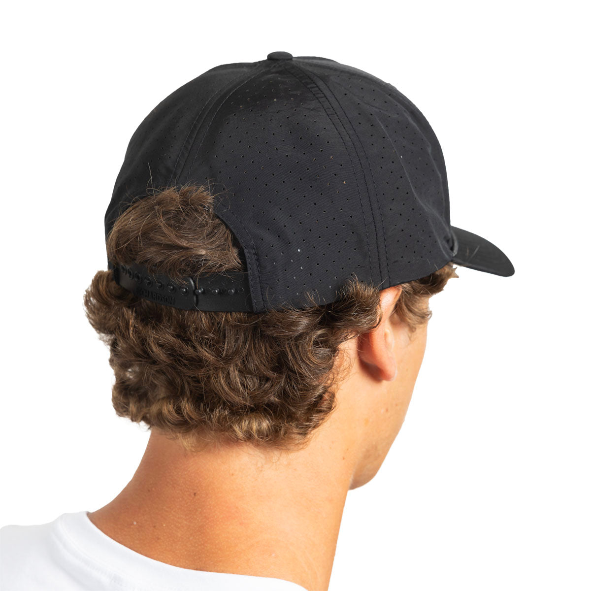 Rear view of a man wearing a black perforated baseball cap, showing the back strap and brim against a plain white background.