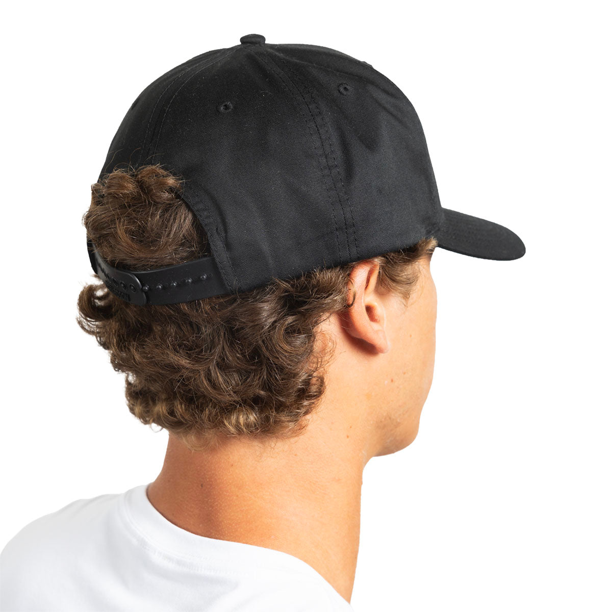 A man shown from the back wearing a black baseball cap with an adjustable strap, photographed against a plain white background.