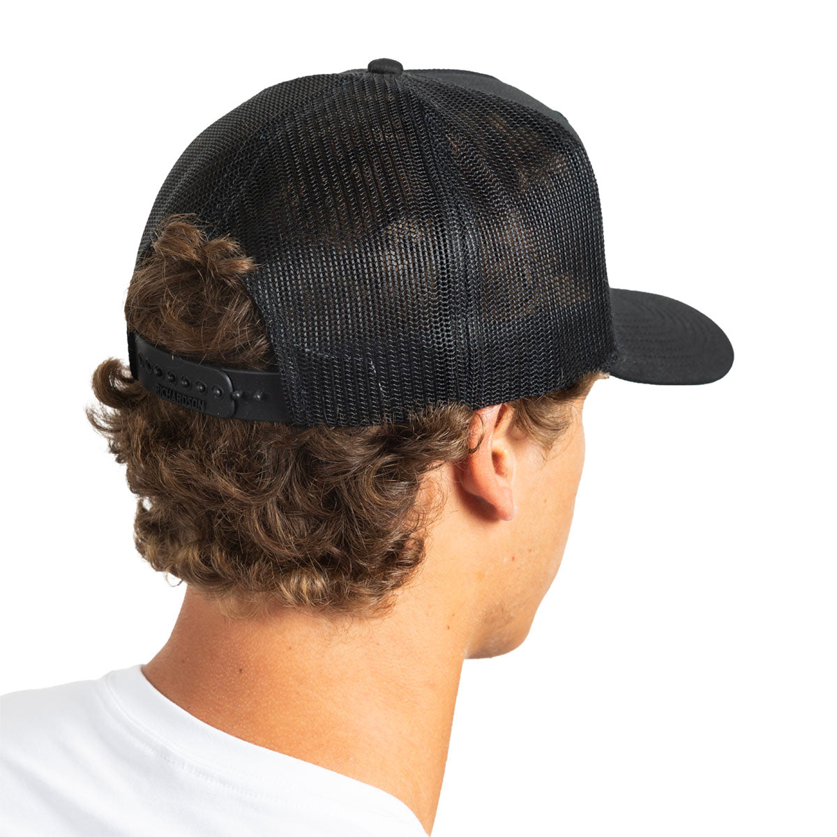 A man shown from the back wearing a black trucker-style cap with a black mesh back and curved brim, photographed against a plain white background.