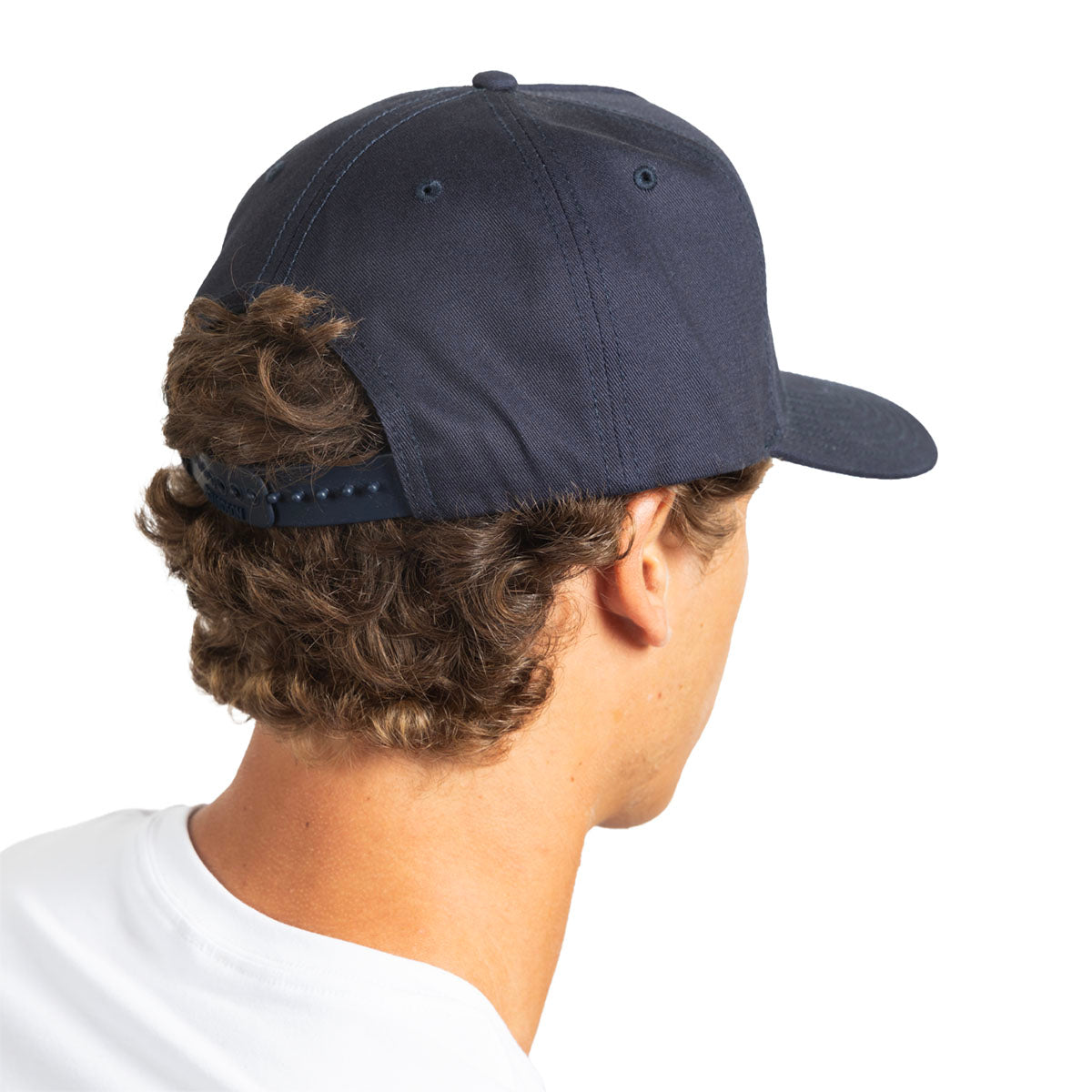 A man shown from the back wearing a dark navy blue baseball cap with a curved brim and an adjustable strap closure, against a plain white background.