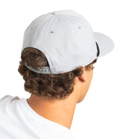 A man shown from the back wearing a light gray baseball cap and a white t-shirt, photographed against a solid white background.