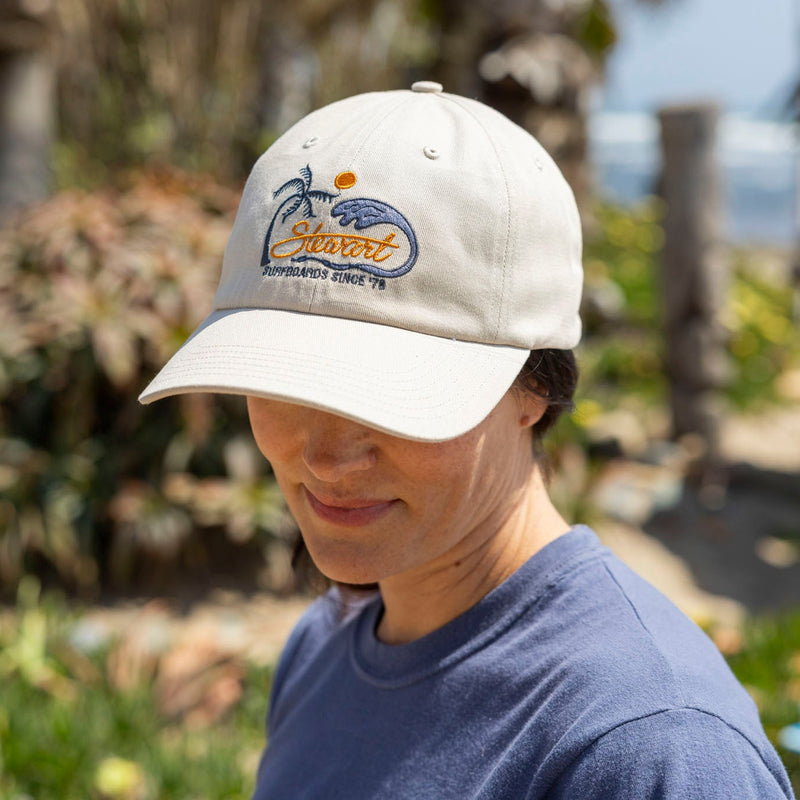 Person wearing a white cap with a logo outdoors