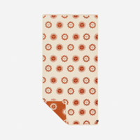 Beige towel with red sun pattern on a white background