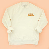 White sweatshirt with 'Just One More Wave' text on a peach background