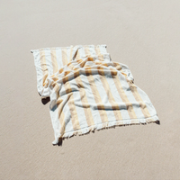 Striped towel on a sandy surface