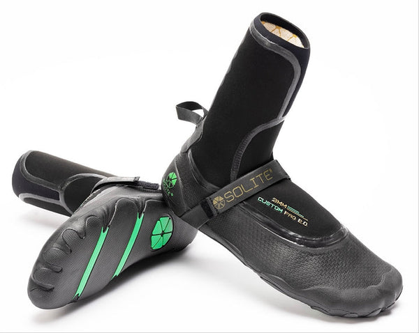 Black surfing booties with green accents on a white background