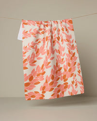 Patterned towel hanging on a line against a beige background