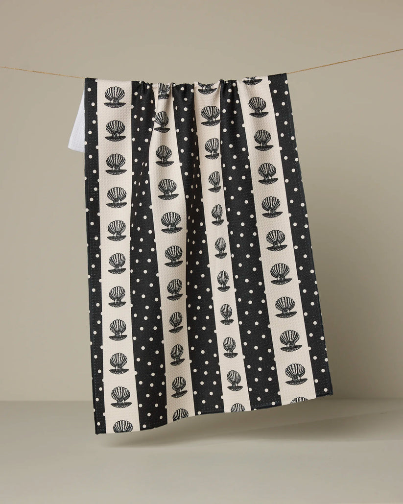 Black and white patterned towel hanging on a line against a beige background