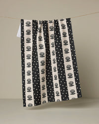 Black and white patterned towel hanging on a line against a beige background