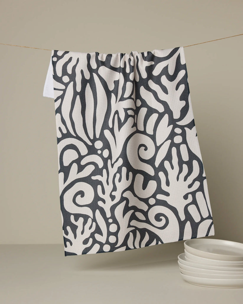 Patterned towel hanging on a line with plates below