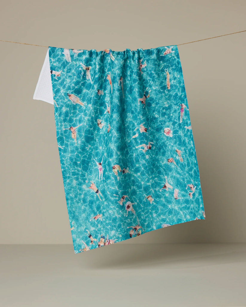 Blue towel with pool and swimmer pattern on a beige background