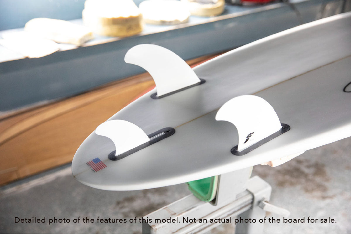 detail of the tail with the included fins on a Stewart Wild Bill mid length surfboard