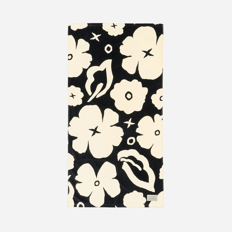 Towel with a black and white floral pattern on a light gray background
