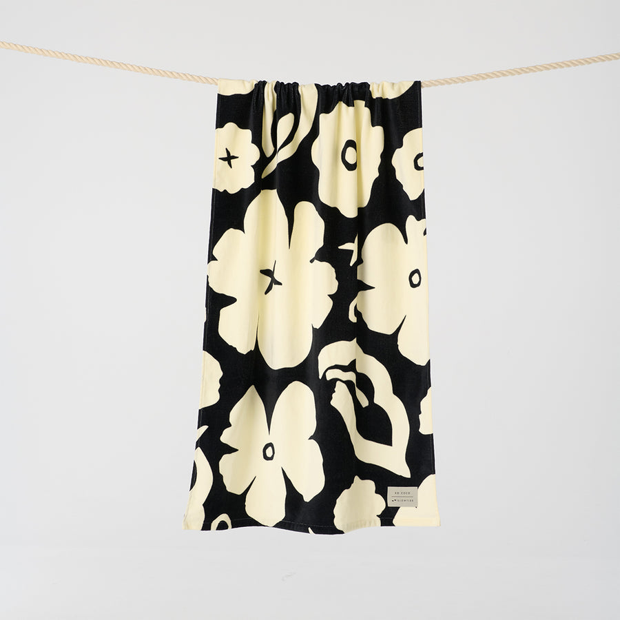 Black drawstring bag with white floral pattern on a light gray background