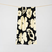 Black drawstring bag with white floral pattern on a light gray background