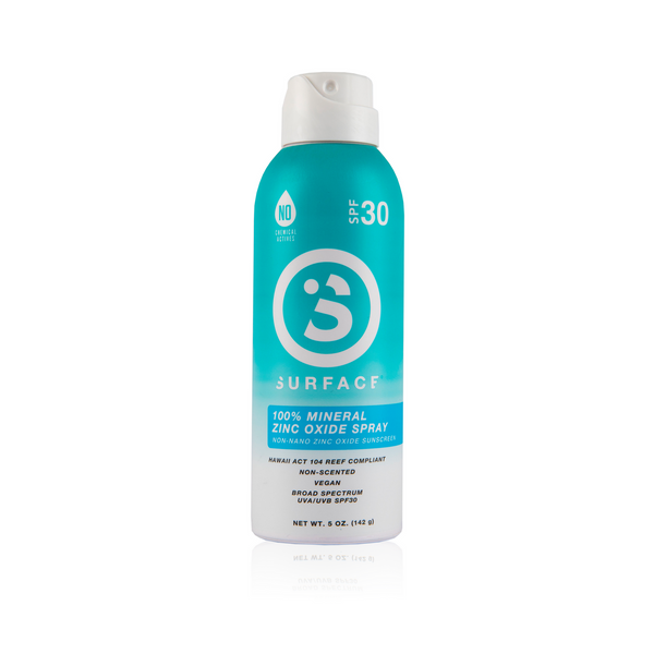 A bottle of Surface SPF30 Mineral Sunscreen Spray. The packaging is predominantly blue with white and green text, and an image of a sunscreen lotion bottle.
