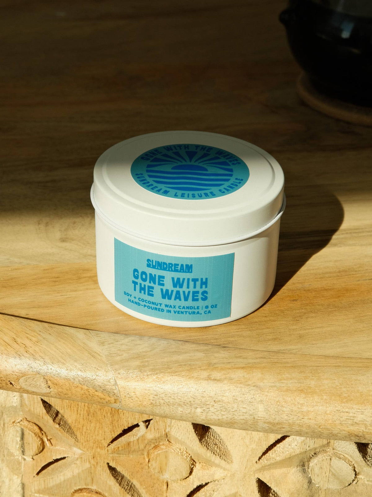 Jar of 'Gone with the Waves' candle on a wooden surface