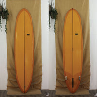 USED Tribute Mid-Length 7'10" surfboard with orange full resin tint and 2 + 1 Fin set up