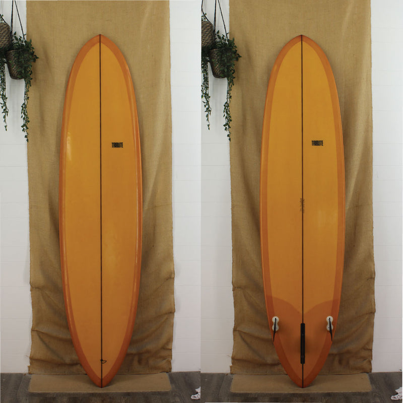 USED Tribute Mid-Length 7'10" surfboard with orange full resin tint and 2 + 1 Fin set up