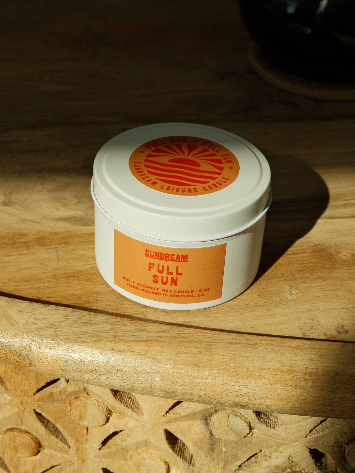 Jar of 'Full Sun' sunscreen on a wooden surface with a visible brand logo.