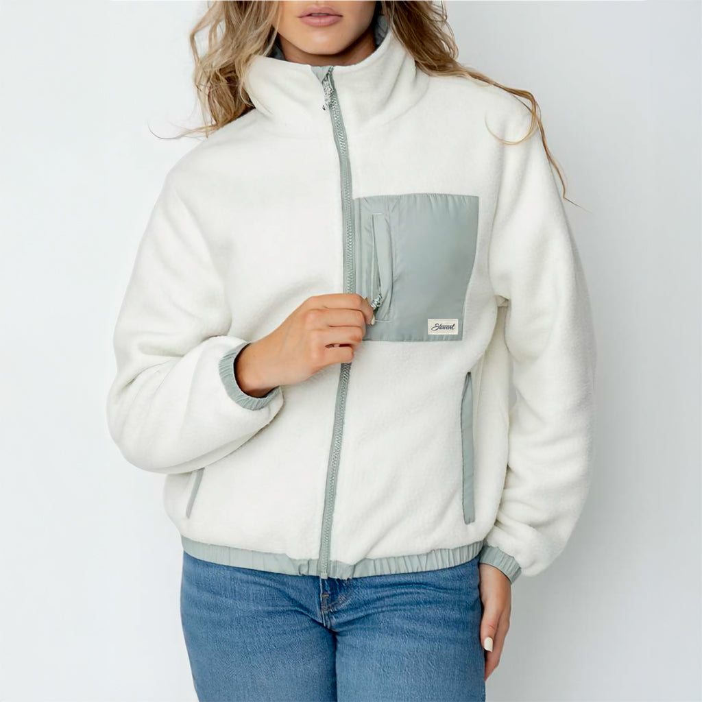 Person wearing a white fleece jacket with gray accents on a plain background