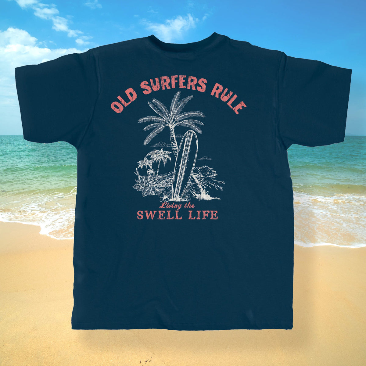 Navy blue t-shirt with 'Old Surfers Rule' design on a beach