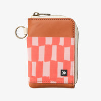 Small wallet with pink and white pattern and brown leather trim on a white background