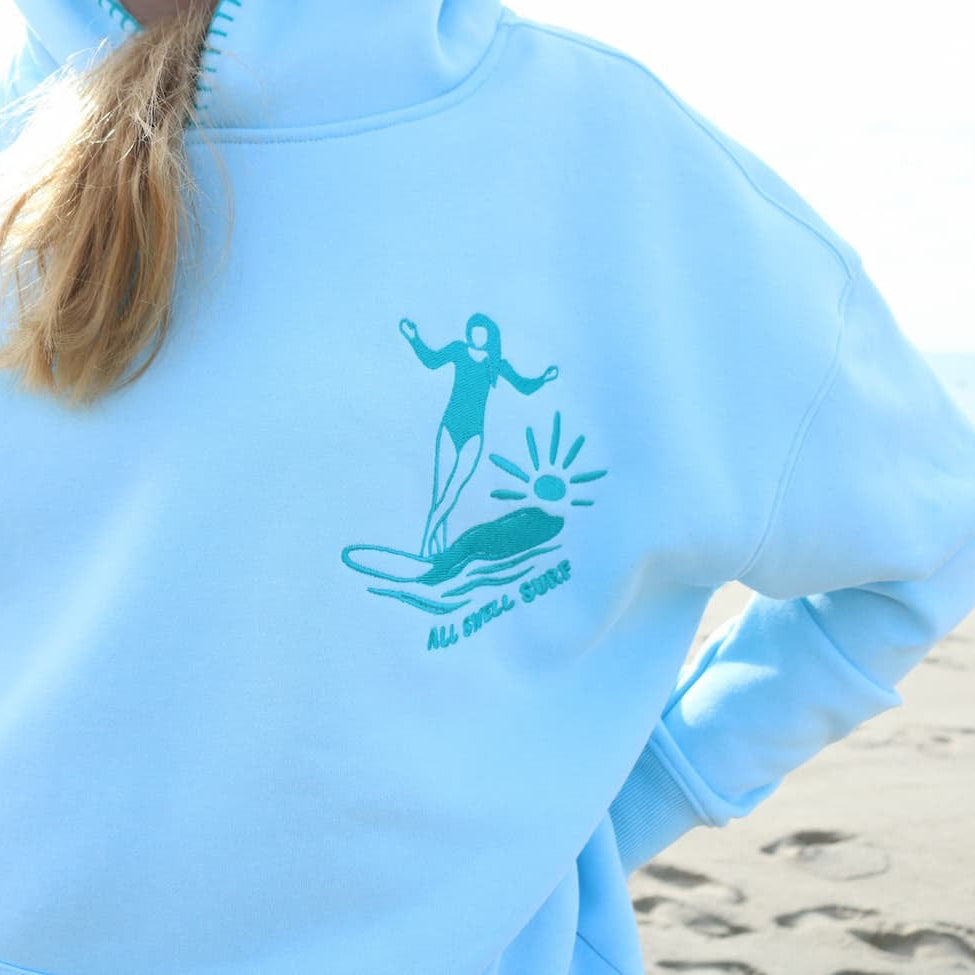 Light blue hoodie with a graphic design on a beach