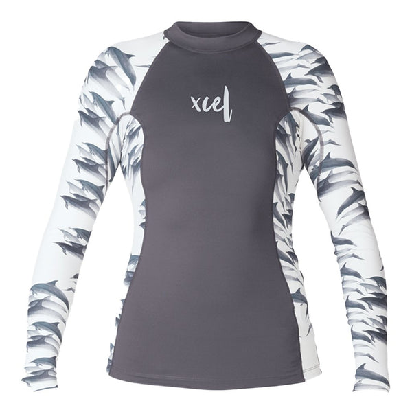 A long-sleeved rash guard for girls with a geometric pattern on the sleeves and a solid gray body, featuring the XCEL logo.