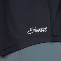 Close up view of Stewart logo on lower left hem of tank top
